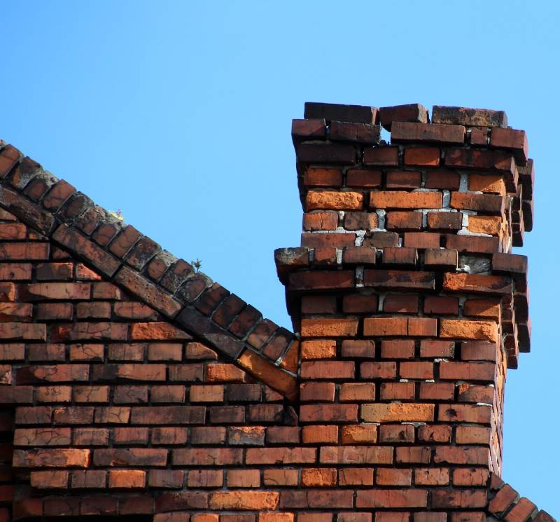 Damaged chimney on an Golf home showing cracks and missing mortar